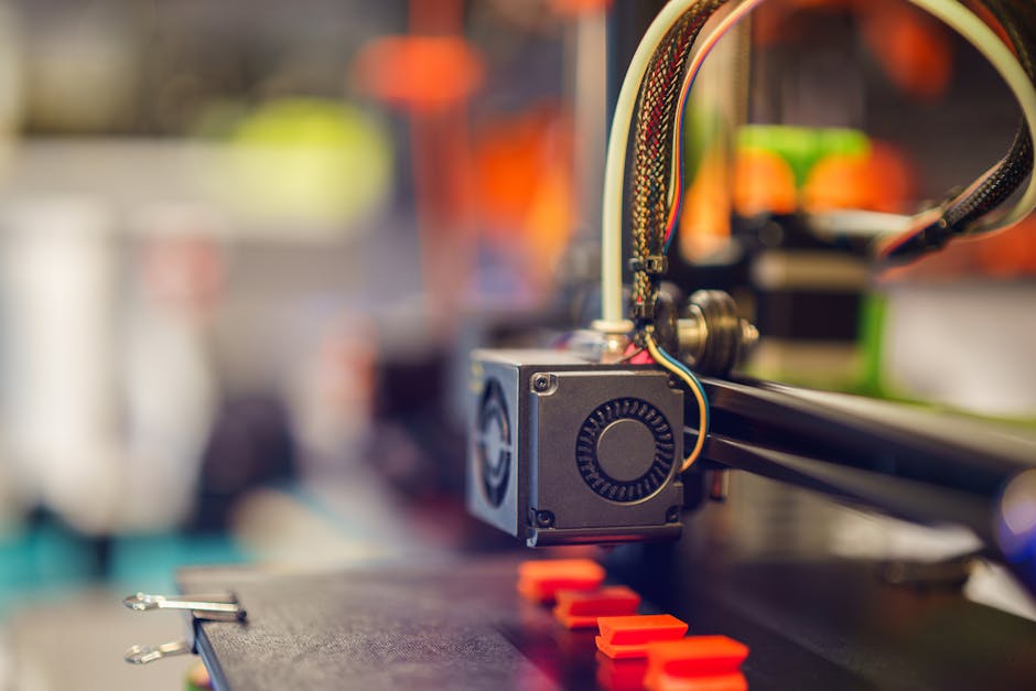 Detaljan makro snimak 3D pisača koji izvlači crvenu plastiku
